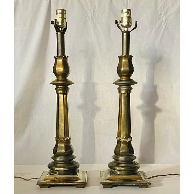A pair of brass table lamps shaped in a traditional candlestick form with tulip tops. Ships within 1-2 days using USPS....