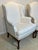 Elegant pair of traditional wingback lounge chairs featuring classic Queen Anne styling with carved cabriole legs in a...