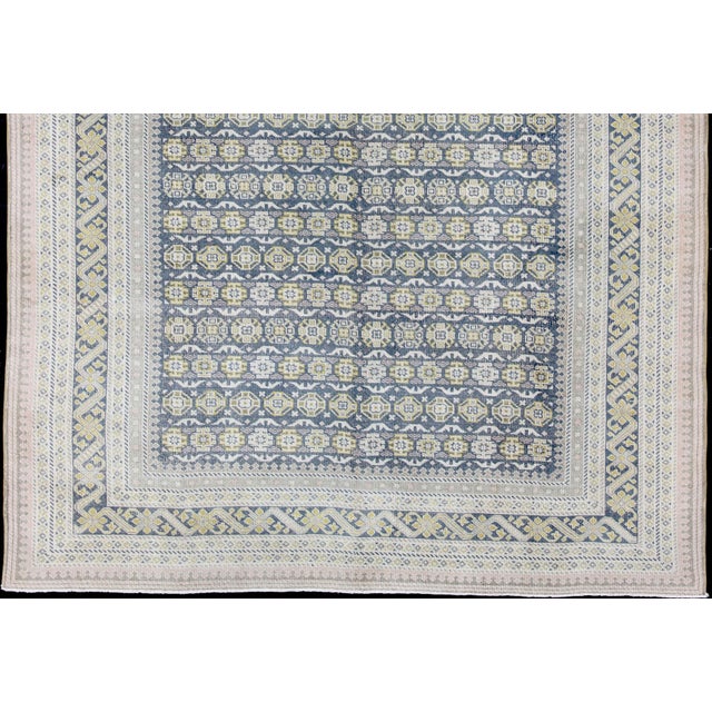 Measures: 9'8 x 13'4. Antique Khotan rug in shades of blue, Taupe, gray, pink, and yellow. Keivan Woven Arts / rug...