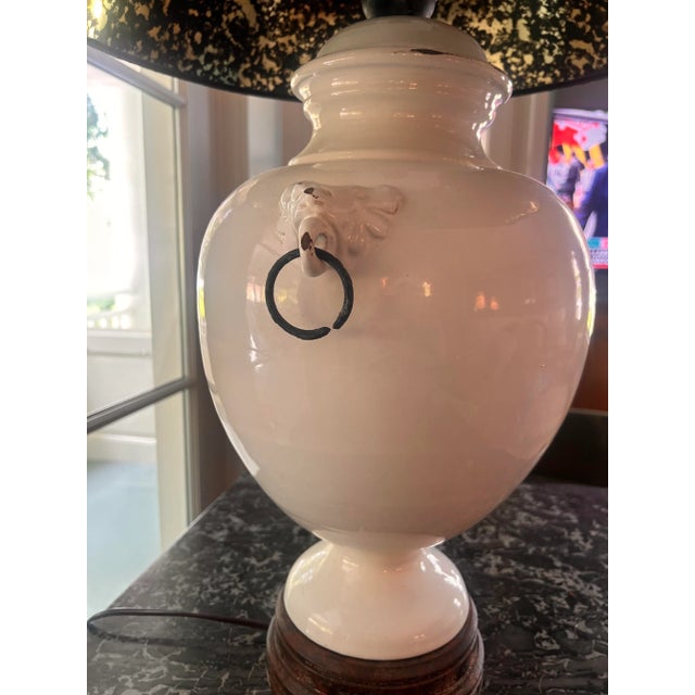 Classical white ceramic urn table lamp with ring flourishes on either side and a dark base. Includes black lampshade with...