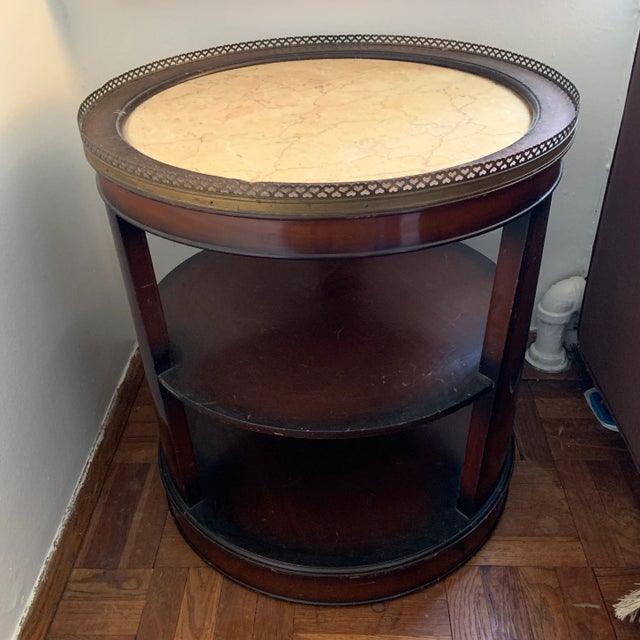 Lovely Art Deco design and timeless shape on this antique wood end table. Brass embellishment surrounds a gorgeous marble...