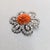 1950s rhodium plated round carved floral faux-coral with marquise and round clear rhinestones in loops surround brooch...