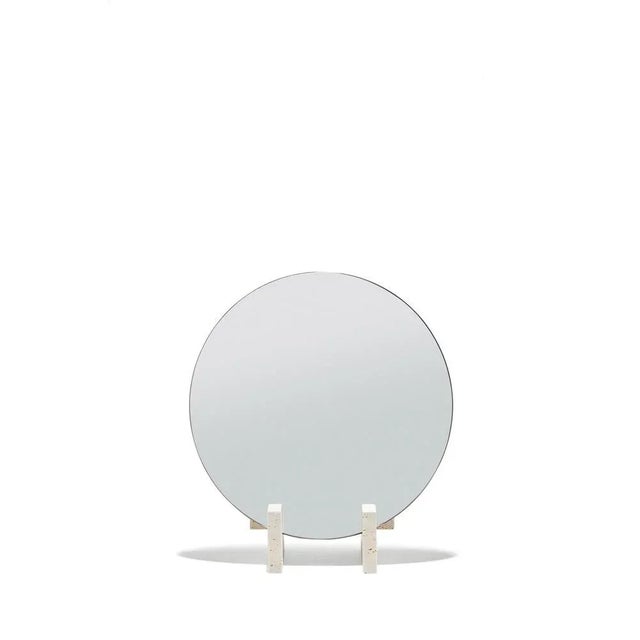 Round mirror held over a travertine marble base, the base holds from the assembly of three pieces like a puzzle. The...