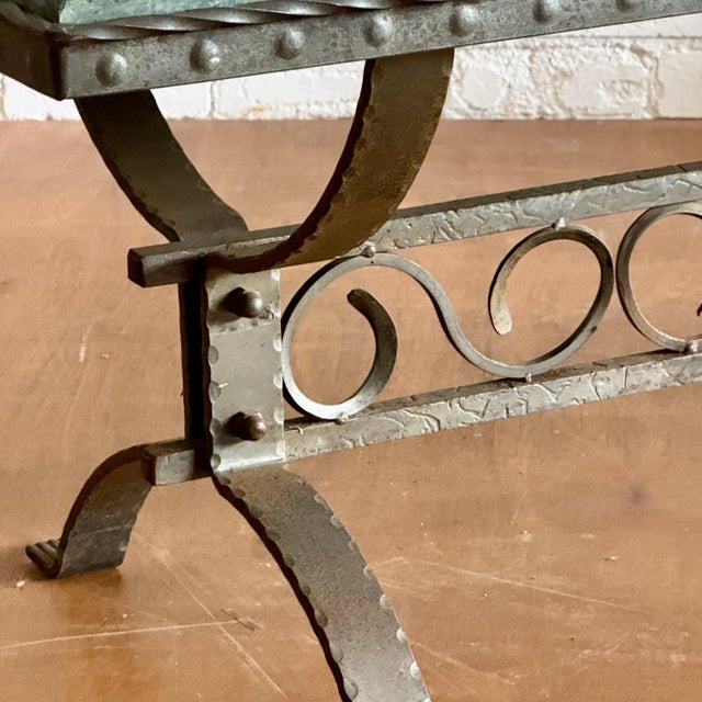 Green marble slab sits upon a sturdy wrought iron base with decorative detailing. Possibly suitable for both inside and...
