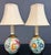 Charming pair of Italian ceramic bedside lamps featuring whimsical hand-painted animal motifs in rich jewel tones against...