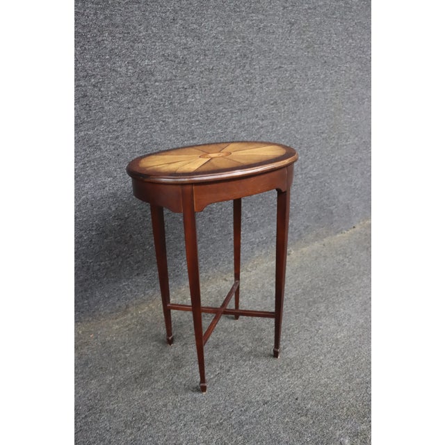 Edwardian mahogany cocktail table featuring an oval parquetry top with radiating veneers and a finely detailed shell inlay...