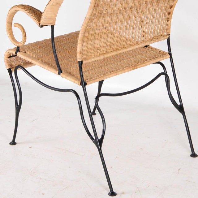 Incredible pair of armchairs in woven wicker and blackened iron. The iron frame has a free-form, organic shape, and the...