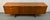 This vintage Mid-Century Modern sideboard was manufactured by Stonehill Furniture in England and features distinctive sled...