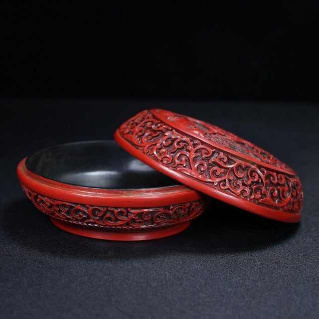 This exquisite vintage Chinese round box is crafted from carved cinnabar lacquer, featuring a rich, deep red color...