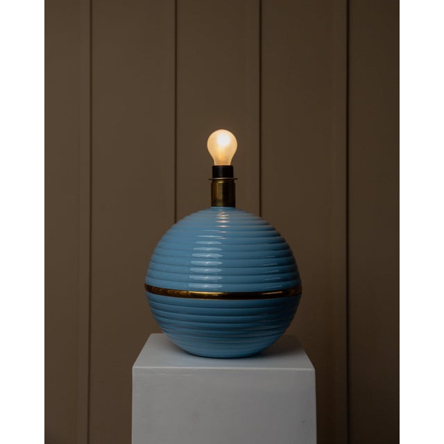 Add a touch of retro charm to your home with this huge, spherical table lamp in light blue and gold. Handmade in italy, it...