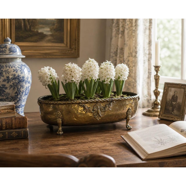 A generously proportioned English Country cachepot crafted from hammered brass in a long oval form. The softly irregular...