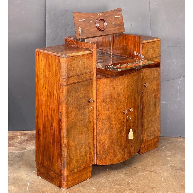 A fine English upright cocktail dry bar cabinet or drinks cupboard - from the Art Deco Period - featuring a handsome burr...