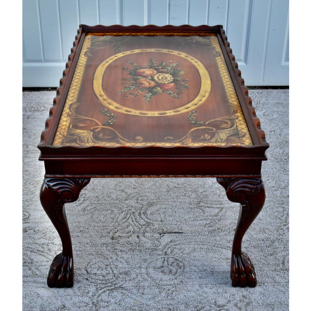 Vintage (1960's) Cocktail Table has a Regency Style. Made of Wood. Mahogany. Carved Wood. The Top has Hand Painted Floral...