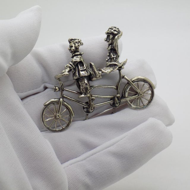 A vintage object depicting two clowns on a bicycle, crafted in Italy between the 1970s and 1980s in silver. The scene...