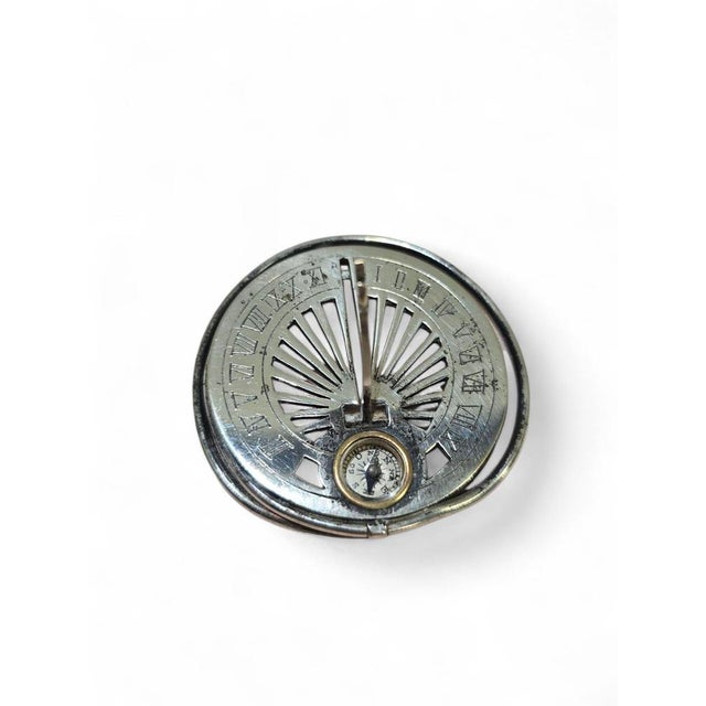 Elegant 19th-century pocket sundial, designed to be worn or carried, made of silvered metal with finely engraved details....