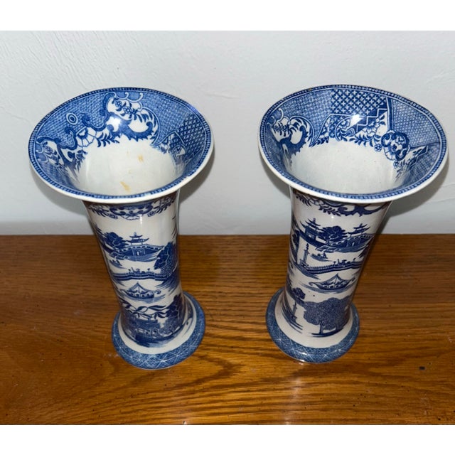 Pair Chinoiserie blue and white trumpet vases. 7.5" tall, top 3.75 wide, bottom 3" wide. Pattern is sailboats, pagodas,...