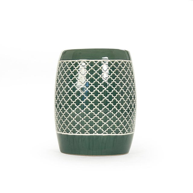 The Gable Garden Stool is a ceramic garden stool with a barrel form and an allover Moroccan quatrefoil trellis pattern in...