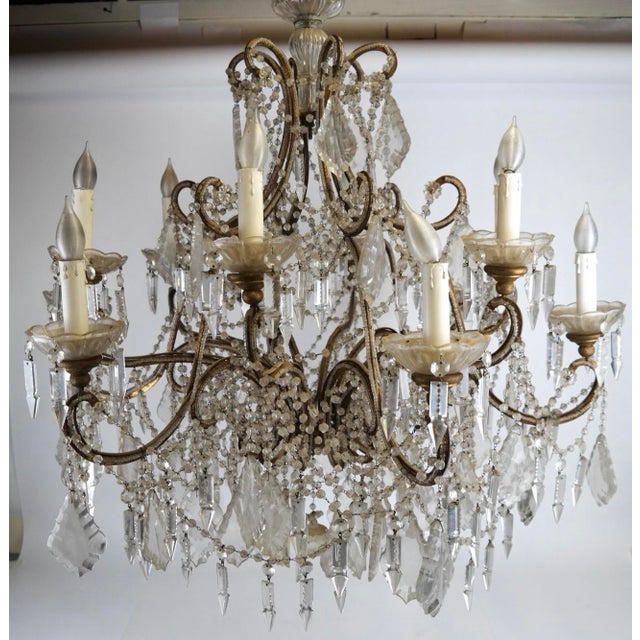 An elegant and richly ornamented twelve-light chandelier in the French Louis XV taste, featuring an elaborate scrolling...