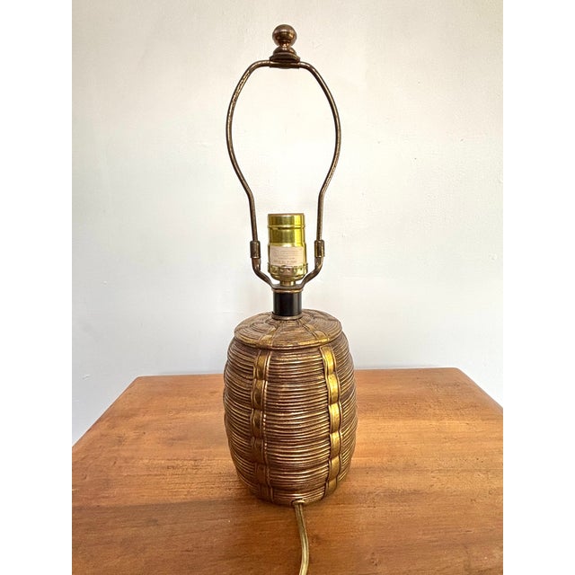 Charming midcentury brass lamp with a black neck, reminiscent of a woven basket with straps. The aged brass allows this to...
