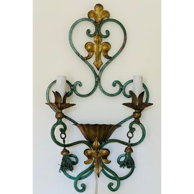A single 2 bulb verdigris and gilt metal sconce. Graceful and simple, the verdigris color with gilt accents is such an eye...