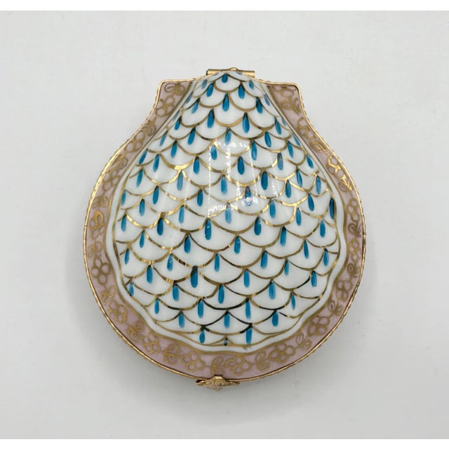 A lovely antique Limoges porcelain clam shell box with a lovely blue and golden gilt design on top and pink perimeter with...