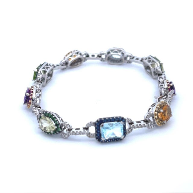 This is a beautiful bracelet, crafted from 18k white gold featuring 9 assorted shape and size gemstone in different...