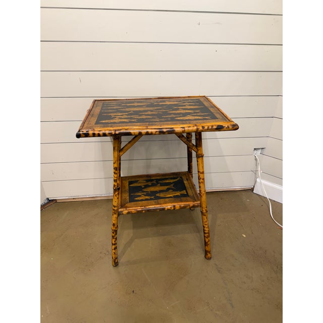 This 19th Century English Bamboo Side table features a delightful variety of fish decoupaged onto the top and lower shelf....