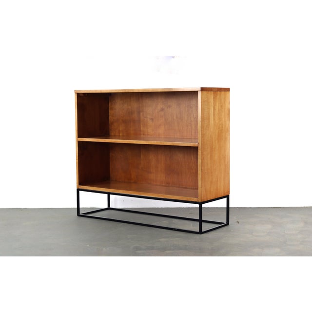 Solid Maple book case, signed by designer Paul Mccobb, with well built iron base on which it stands. This piece will bring...