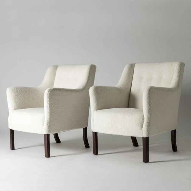 Pair of elegant lounge chairs by Einar Larsen. Contemporary look, upholstered with white bouclé fabric. Seat height 42 cm....