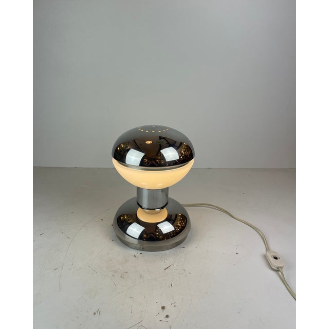 Beautiful table lamp shaped like a diabolo, made of shiny chrome and white opaline glass. Iconic piece of the Space-Age...