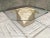Vintage coffee table with beveled octagonal glass top, brass x-support, atop smooth polished and rough cut tessellated...