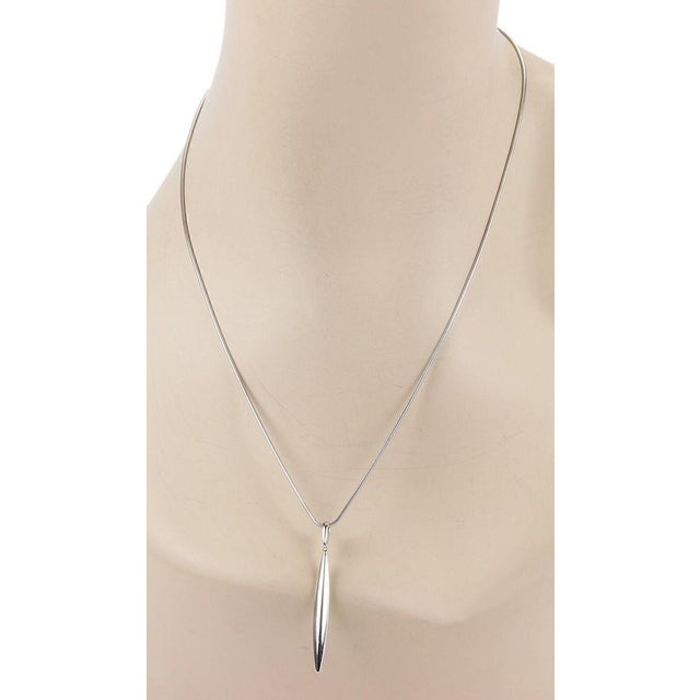 Crafted by the renowned Tiffany & Co., this 18k white gold pendant necklace is a testament to elegance and modern style....
