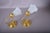 Pair of brass wall sconces with beaded round backplates, ring-pull details and single curved arms supporting frosted...