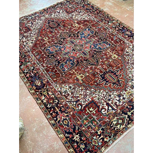 Antique Persian Heriz rug, hand knotted in Iran from 100% wool. Measuring 8’2” x 11’8”, the rug features a bold...
