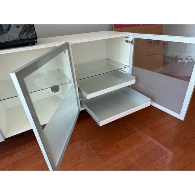 Frosted tempered glass doors and glass shelves in aluminum frames with steel base and finished cut outs in the back for...