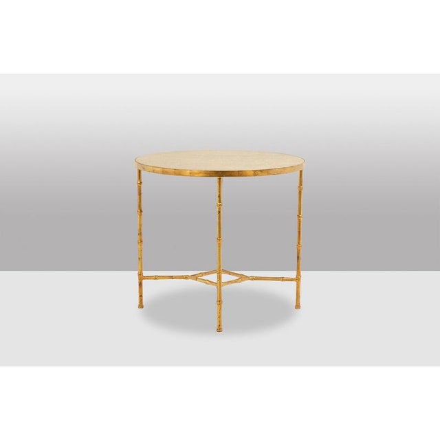 Round pedestal table with golden metal base in bamboo style. Gray marble top. Made in the 20th century. This piece is...