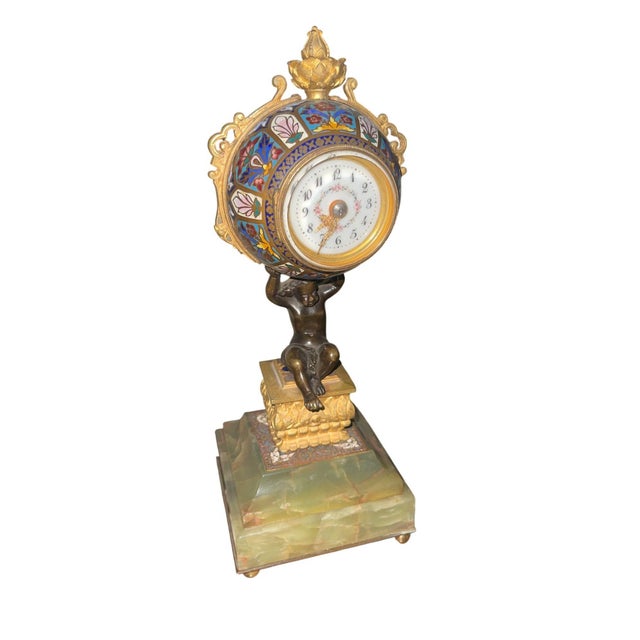 Decorative 19th century French mantel clock featuring a richly ornamented champlevé enamel clock case raised above a...