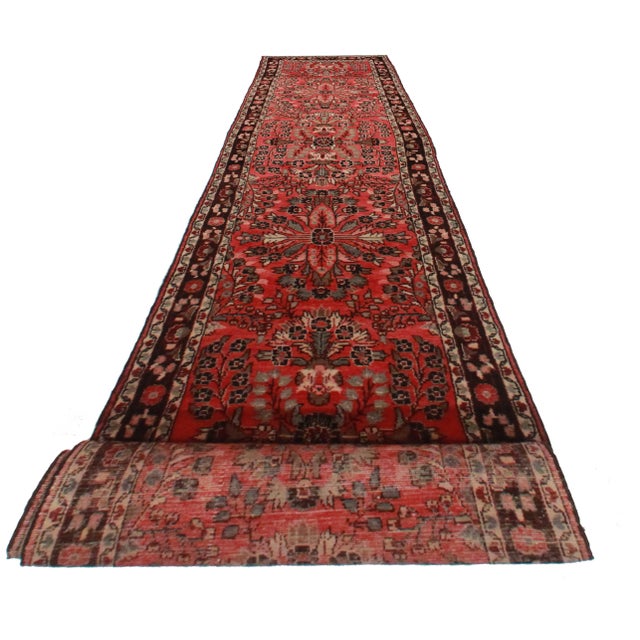 Here is an extra long Vintage Persian Mehraban runner. Made of hand-knotted wool. Features a luxurious red background and...