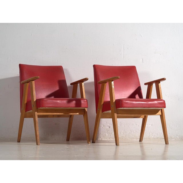 Red vintage style armchairs (c.1960). Set of 2 pieces Approximate age: 60 years Material: Solid birch wood and synthetic...