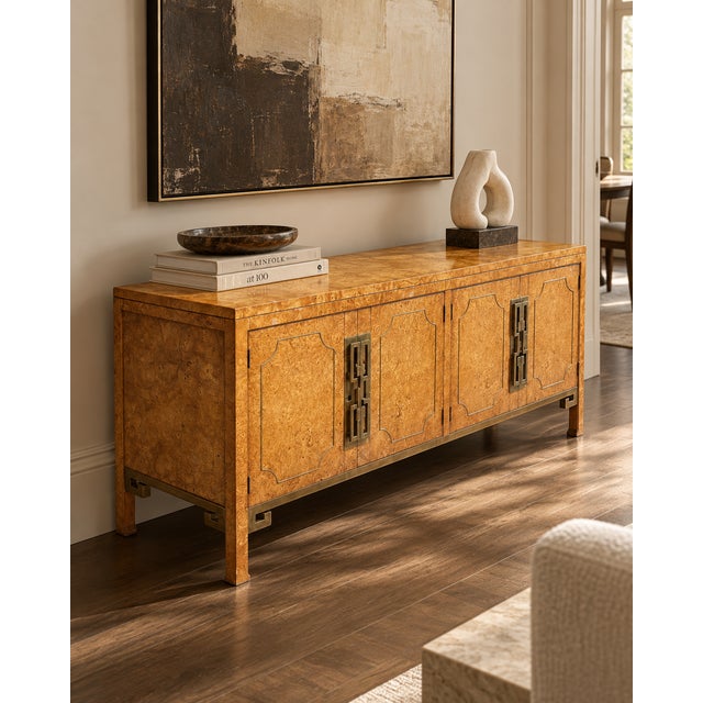 An exquisite 1970s Hollywood Regency credenza attributed to Mastercraft, distinguished by its richly figured burlwood...