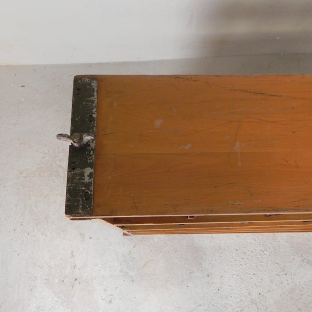 This cabinet was used in the army. By removing the 2 steel bars, the sides can be removed and all the shelves collapse...