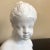 A vintage white Italian pottery bust of a young girl. Marked 'Italy.'