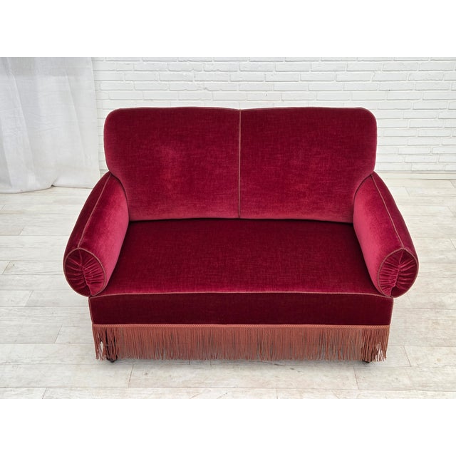1950s, Danish 2-seater drop arm/back sofa. Cherry-red furniture velour, beech wood legs with brass wheels, brass springs...