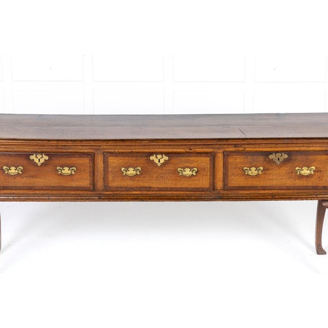 18th century george iii english oak dresser base of large scale with three deep drawers which have large gilt brass...