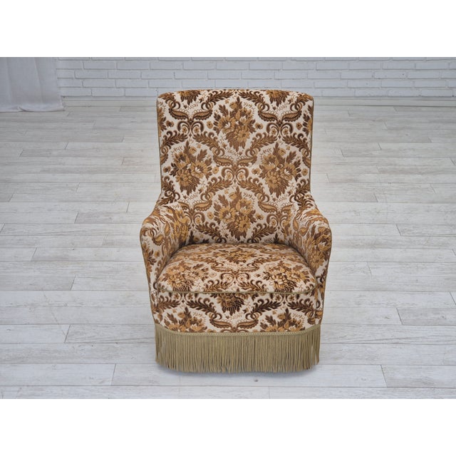 1960s, Danish armchair. Brown/beige furniture velour fabric, brass springs in the seat, ash wood legs. The chair was...