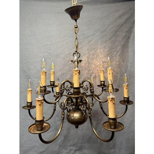 A well-crafted Flemish brass chandelier featuring twelve scrolling branches arranged over two tiers, offering balanced...