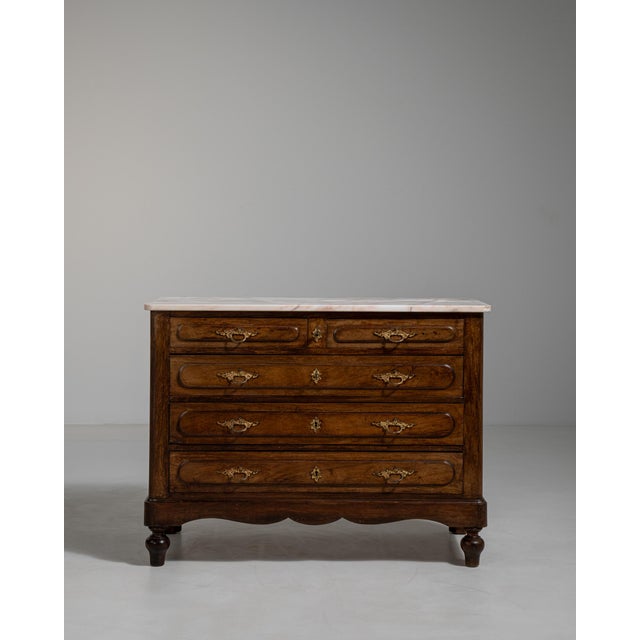 A refined chest combining warm oak with a contrasting marble top. The piece balances durability with elegance, offering...