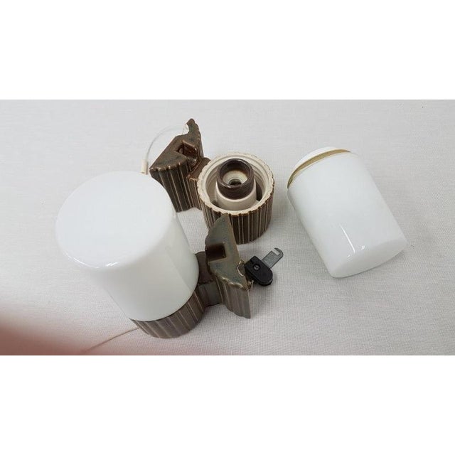 A pair of bathroom lamps of green ribbed ceramic with an opaline shade, single light. This model 6020 is attributed to:...