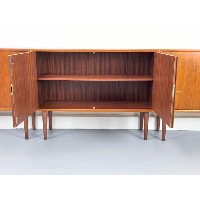 Beautiful set of three compact teak cabinets, each with one adjustable shelf. These pieces are from the WK Möbel 465...