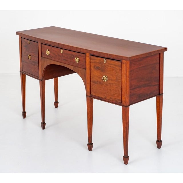 This bow front sideboard is raised upon tapered legs with spade feet. Having an arrangement of 2 oak lined drawers and 1...